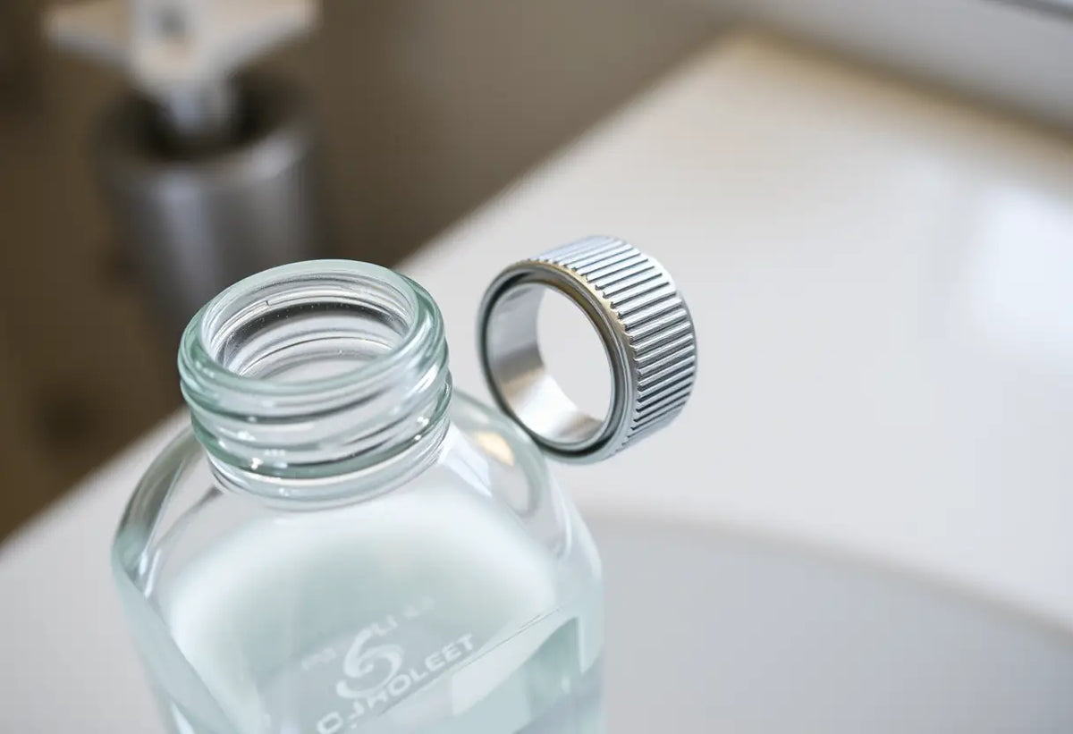 Plan rapproché d'un bouchon métallique sur une bouteille de gel lubrifiant dans une salle de bain
