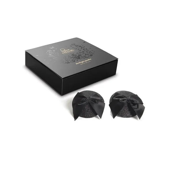 Cache-tétons pailletés noirs avec nœud satin, style burlesque, élégance années folles, dans boîte noire chic.