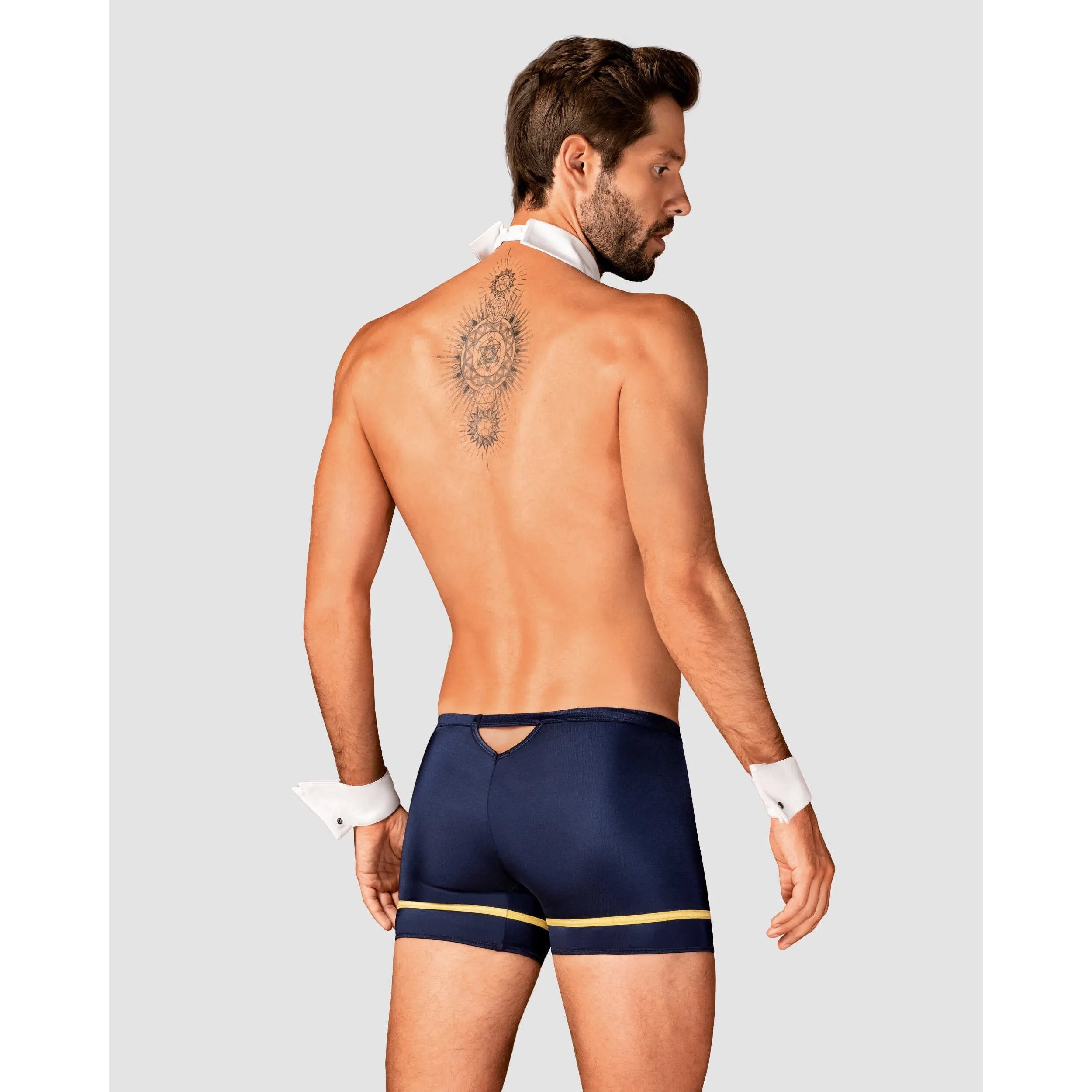 Homme en caleçon bleu et doré, cravate blanche, lunettes, costume pilote sexy, ambiance glamour et séduisante.