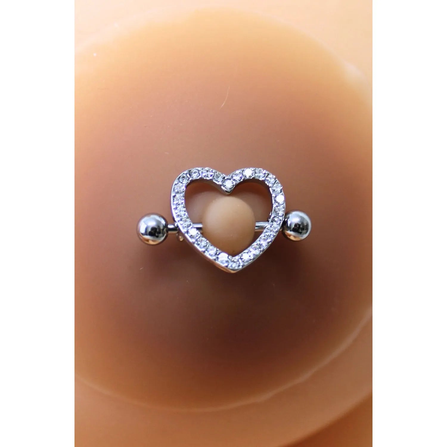 Cache-tétons silicone peau métissée avec piercing cœur faux diamant, adhésifs et discrets, confortables et réutilisables.