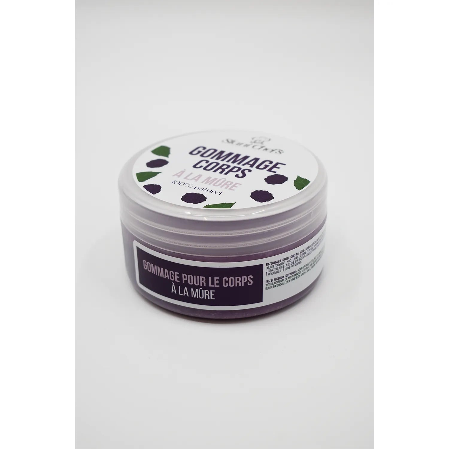 Pot de gommage corps mûre et huile d'amande douce, couvercle blanc avec motifs de mûres, hydratation peau soyeuse.