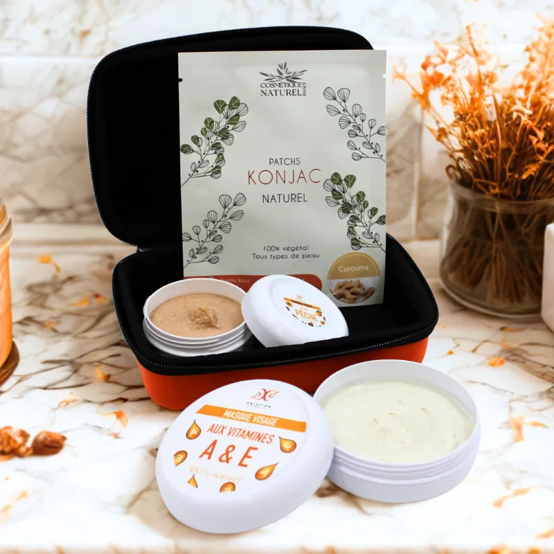 Coffret soin visage bio avec gommage, masque et patchs yeux naturels, présenté dans une trousse élégante sur fond marbré.