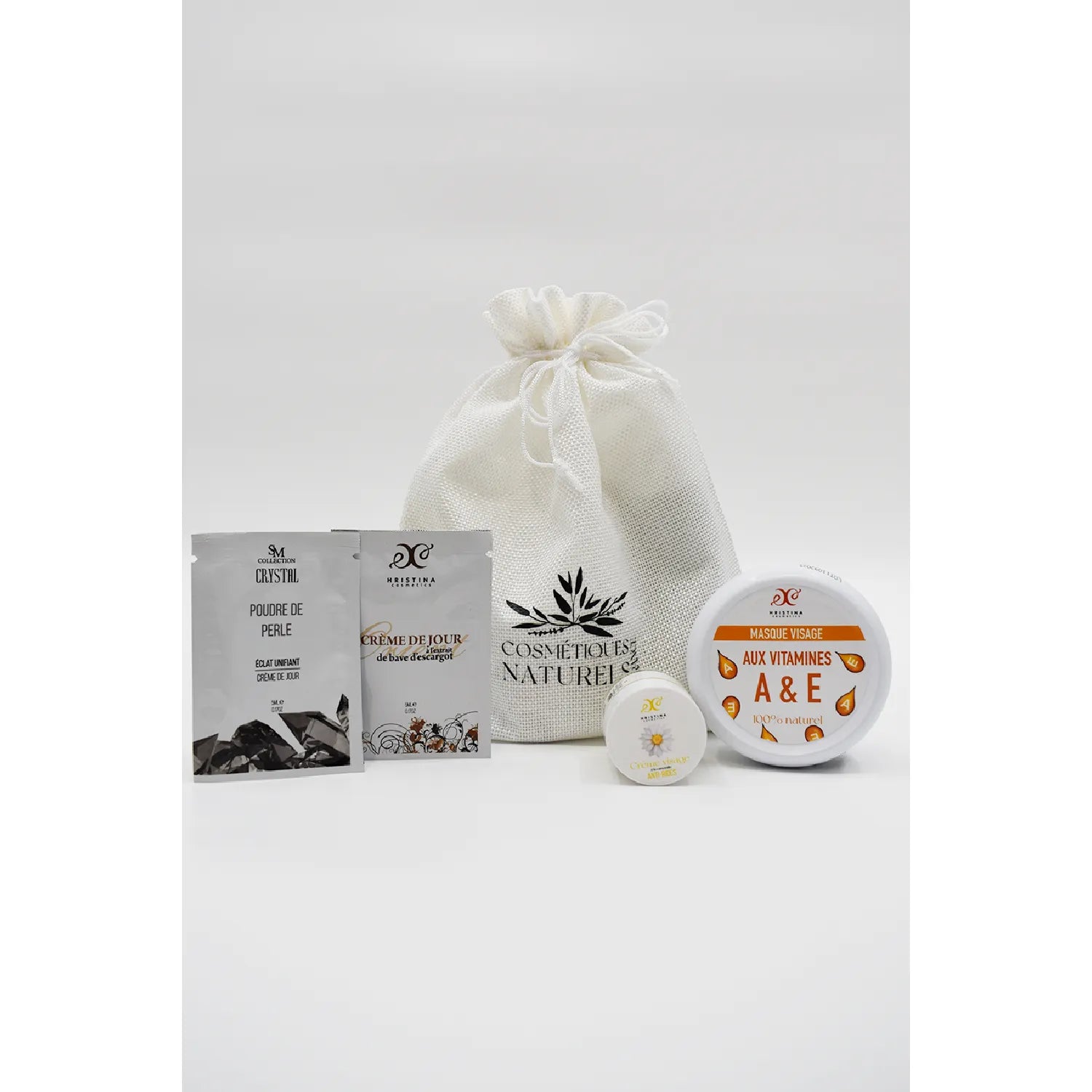 Coffret soins visage anti-rides, sachets et pots, ingrédients naturels, vitamines, kaolin, collagène, fond blanc.