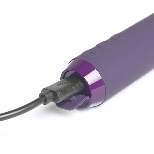 Vibromasseur violet ergonomique en silicone, compact et rechargeable, avec câble USB inséré pour une utilisation mains lib...