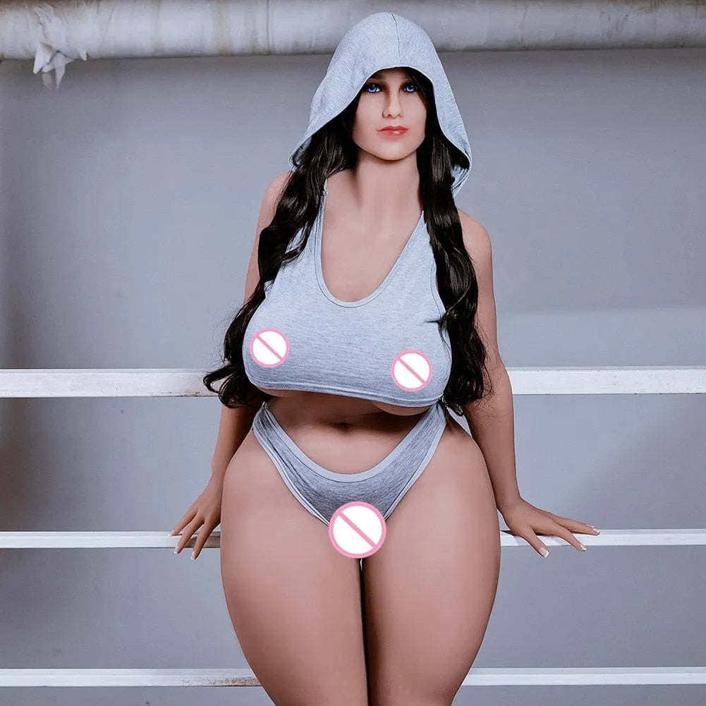 Poupée adulte réaliste en silicone, cheveux longs bruns, vêtue d'une tenue grise, posée contre une rambarde.