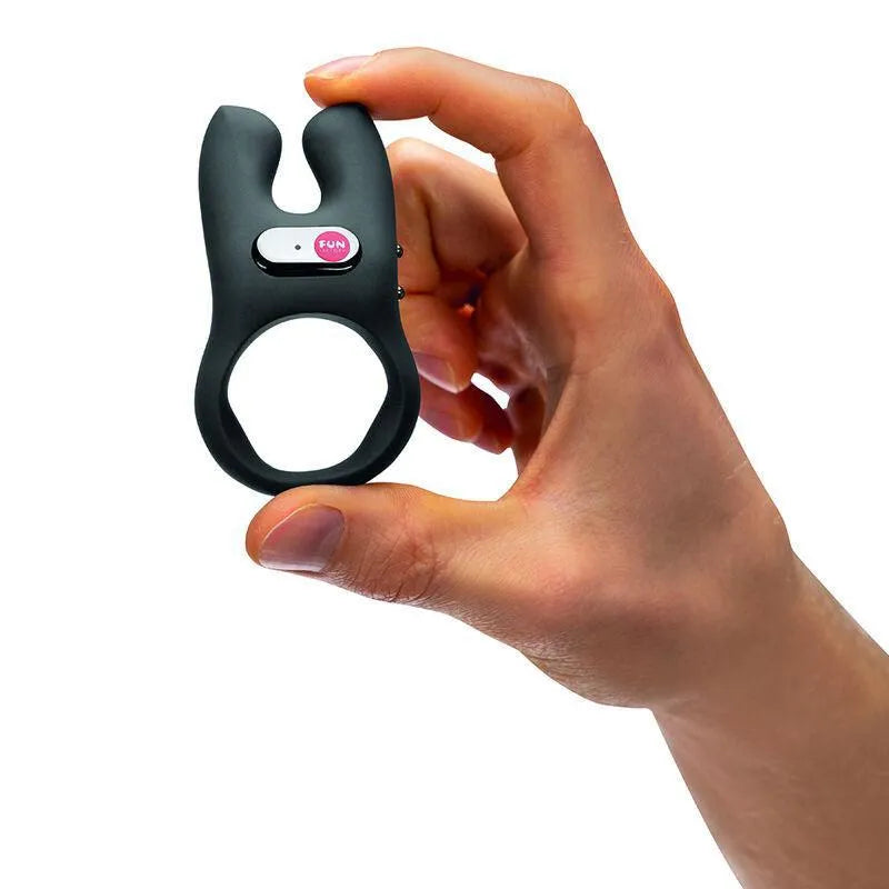 Anneau pénien vibrant noir ergonomique en silicone, double moteur, tenu en main, pour stimulation clitoridienne et pénienne.