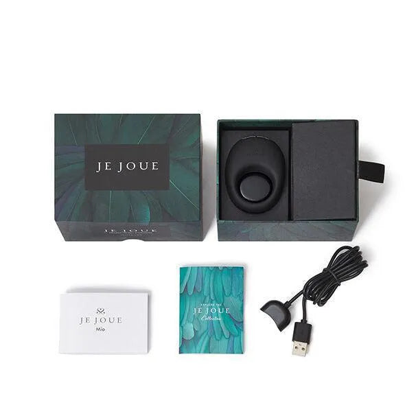 Anneau vibrant noir Je Joue Mio dans boîte ouverte, avec câble USB et manuel, sur fond blanc.