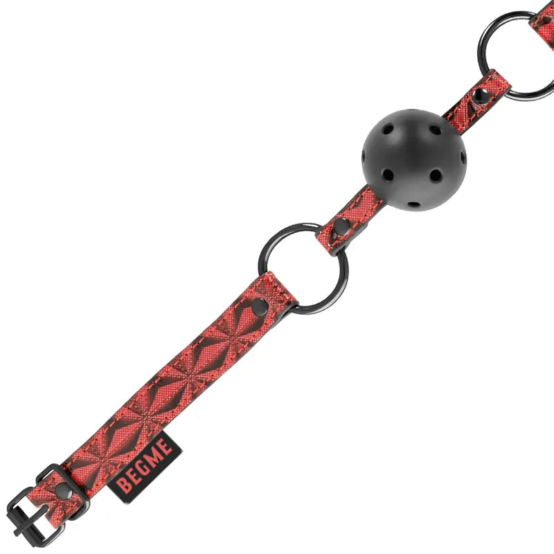 Bâillon BDSM rouge en cuir végane avec boule noire ventilée, sangle réglable et détails en métal sans nickel.