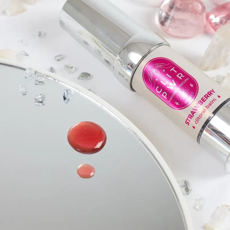 Flacon argenté de baume chauffant clitoridien fraise 15ml sur fond blanc, goutte rouge visible, produit naturel.