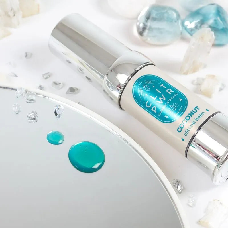 Baume stimulant clitoris chauffant, flacon argenté 15ml, sur fond de cristaux et miroir, intensifie plaisir féminin.