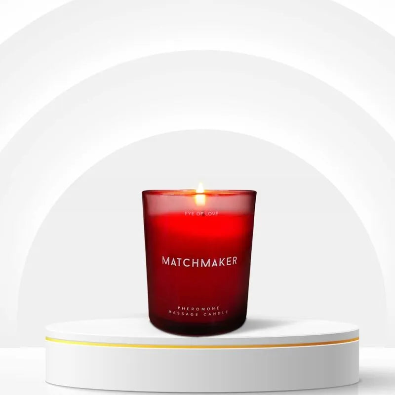 Bougie massage phéromones rouge, cire fondue, parfum cèdre-cassis-citron, sur socle blanc, ambiance bien-être.