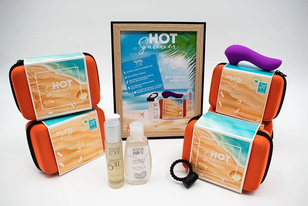 Coffret couple été sensuel: stimulateur violet, anneau noir, huile massage, lubrifiant, trousses orange, cadre plage.