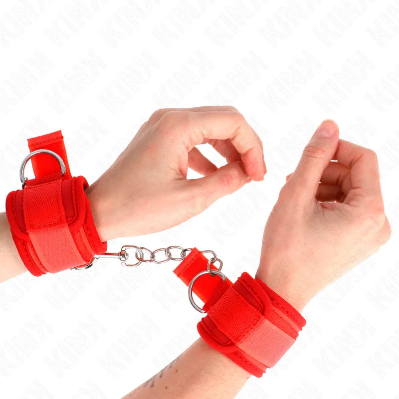 Bracelets BDSM rouges en cuir véritable, rembourrés, avec boucles métalliques et velcro réglables, portés sur poignets.