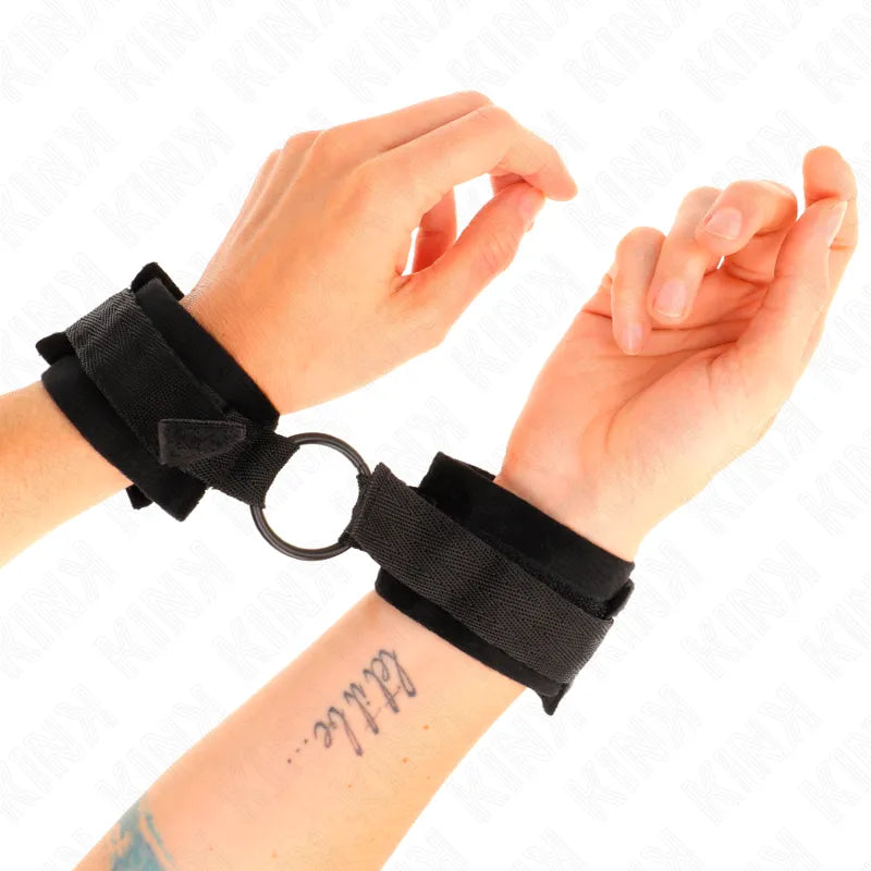 Bracelets BDSM en cuir végétalien noir, ajustables, rembourrés, avec boucle métallique, portés sur poignets.