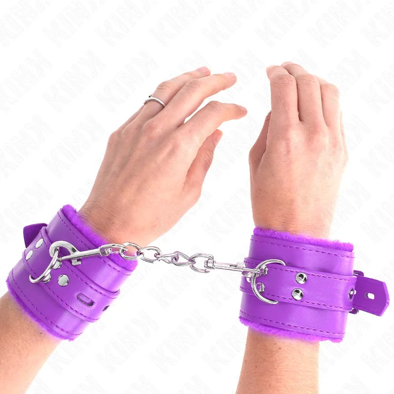 Bracelets BDSM violets en cuir végan, ajustables, rembourrés, avec boucles et anneaux, attachés par une chaîne métallique.