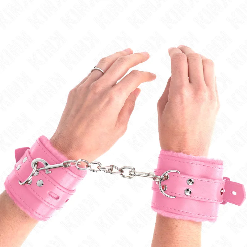 Bracelets BDSM rose en cuir végétalien, rembourrés, réglables, avec chaîne métallique, design moderne et durable.