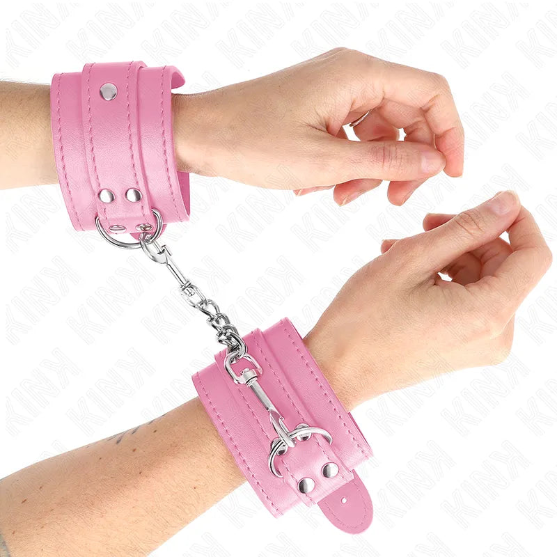 Bracelets BDSM en cuir rose, rembourrés, avec fermetures robustes et anneaux métalliques pour confort et sécurité.