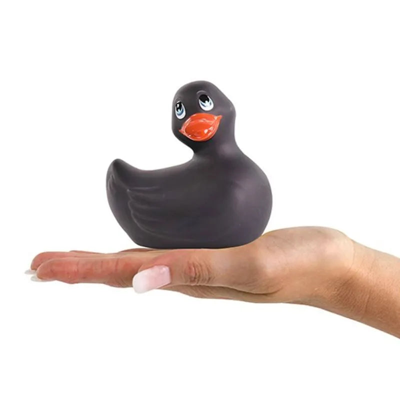 Canard vibrant noir étanche, forme classique, posé sur une main, idéal pour massage et détente sous la douche ou bain.