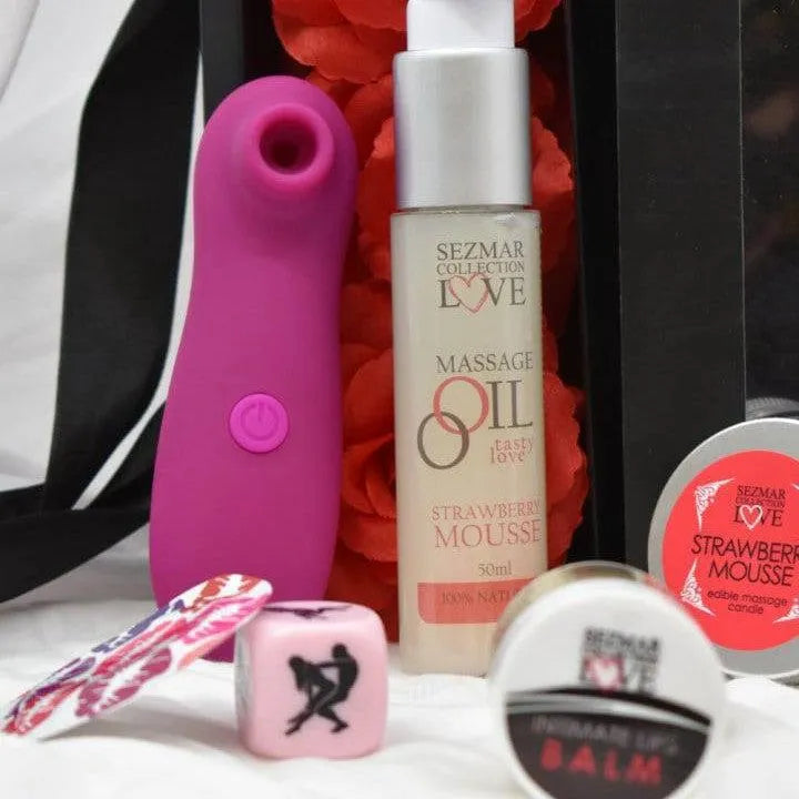 Coffret coquin avec stimulateur violet, huile massage, bougie, pétales rouges, dés rose, pour couple romantique.