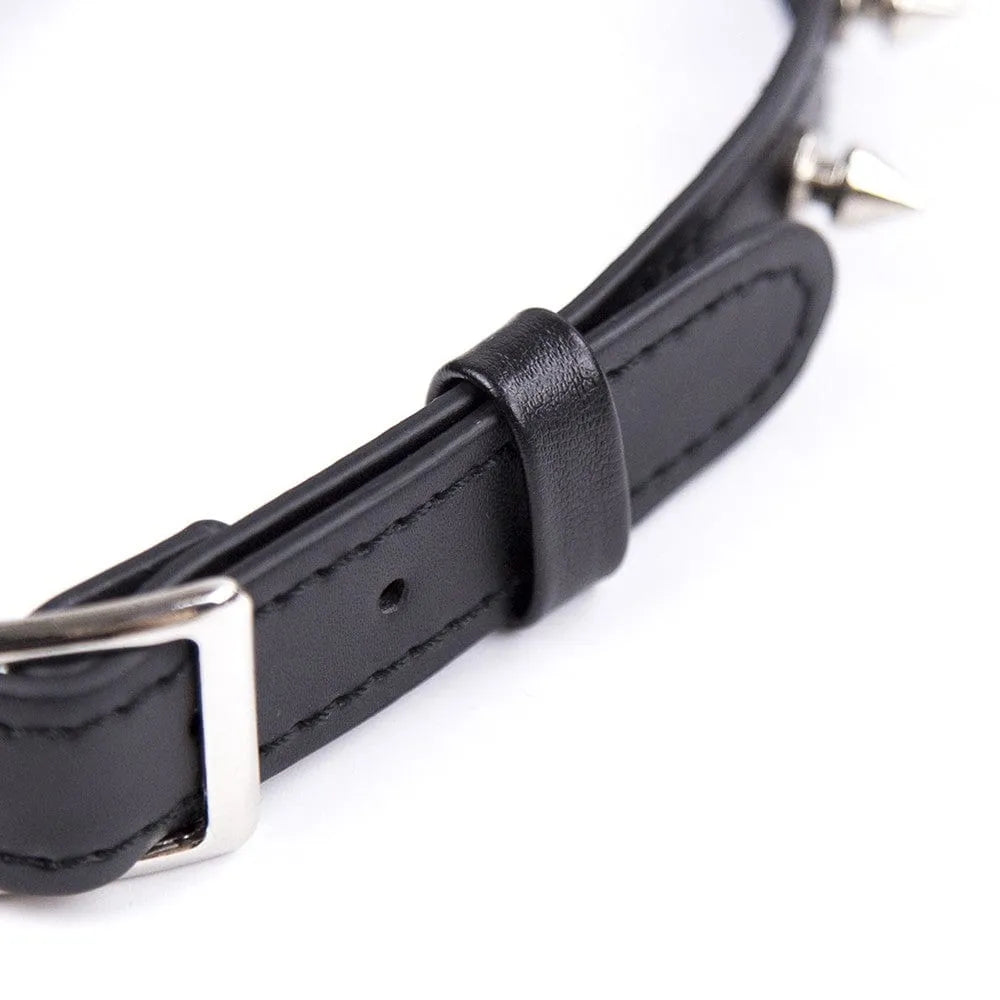 Collier BDSM noir en PVC avec picots argentés, réglable, rivets métal, robuste et élégant, pour jeu de rôle fétichiste.
