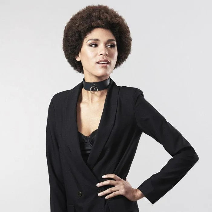 Collier bondage noir en polyuréthane recyclé, design minimaliste et élégant, porté sur une tenue moderne et sophistiquée.
