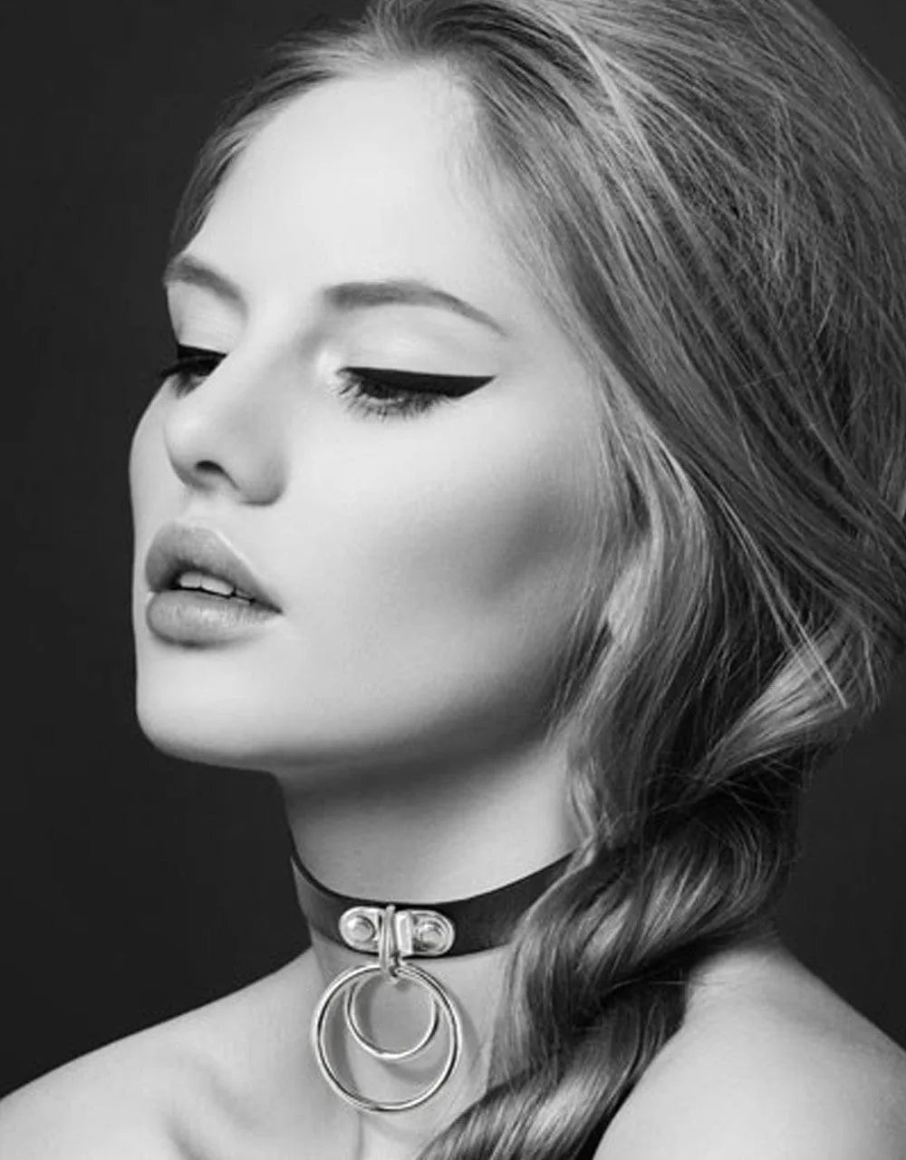 Collier cuir noir SM réglable avec double anneau argenté, style fétichiste, porté par une personne, ambiance sensuelle.