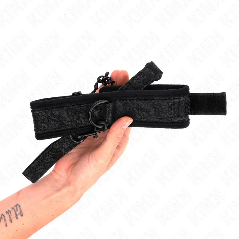 Collier BDSM noir en cuir véritable avec boucles ajustables, design élégant et robuste, tenu par une main.