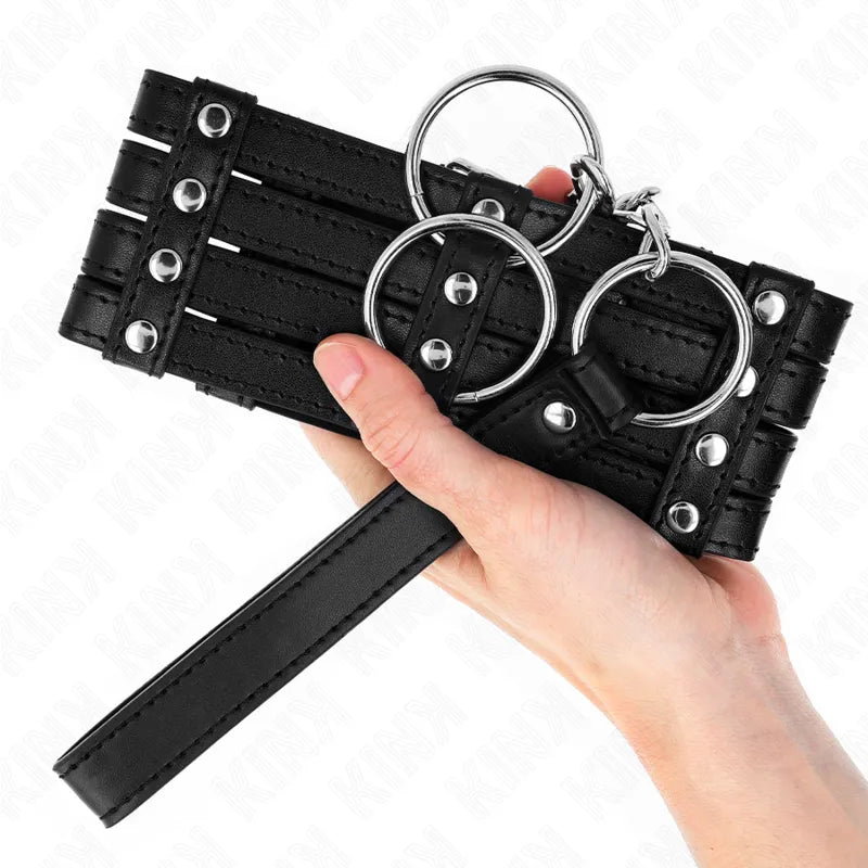 Collier et laisse BDSM en cuir noir, boucles métalliques polies, design élégant et ergonomique, tenue en main.