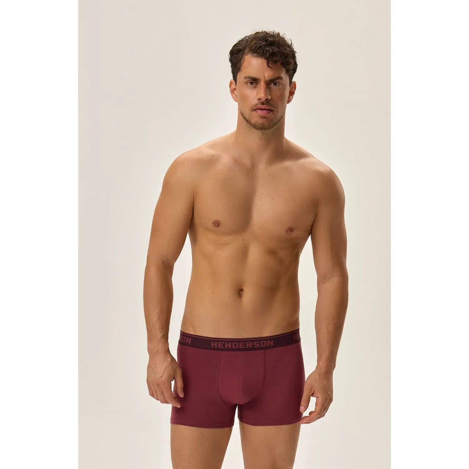 Boxer Henderson rouge ajusté, ceinture élastique noire logo visible, homme debout, fond neutre.
