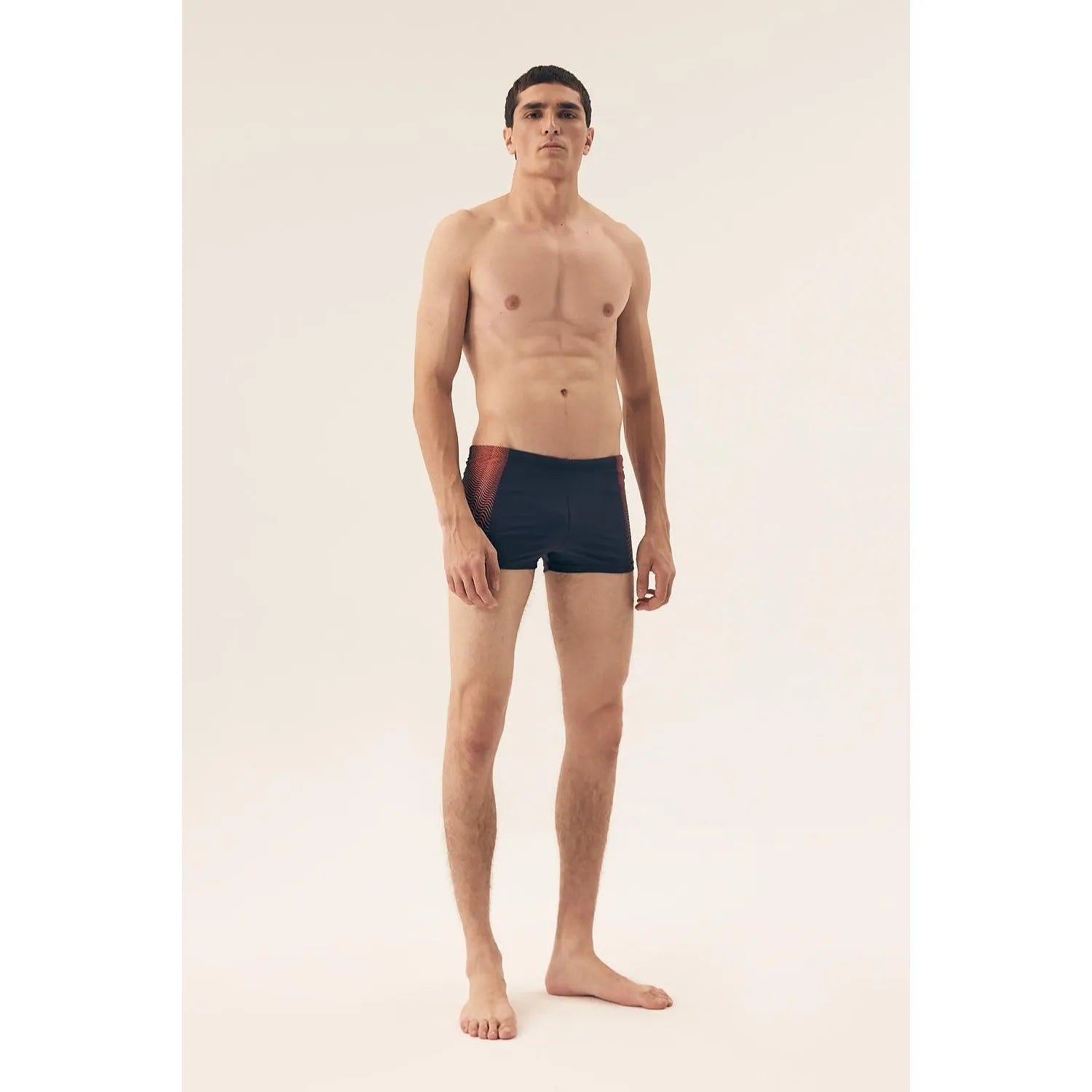 Boxer homme moderne bleu avec rayures rouges, design épuré, tissu élastique respirant, silhouette mise en valeur.