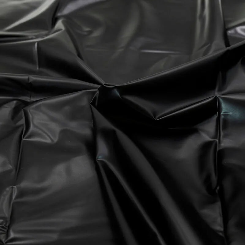 Drap jetable imperméable noir en PVC, texture lisse et brillante, idéal pour jeux adultes et protection hygiénique.