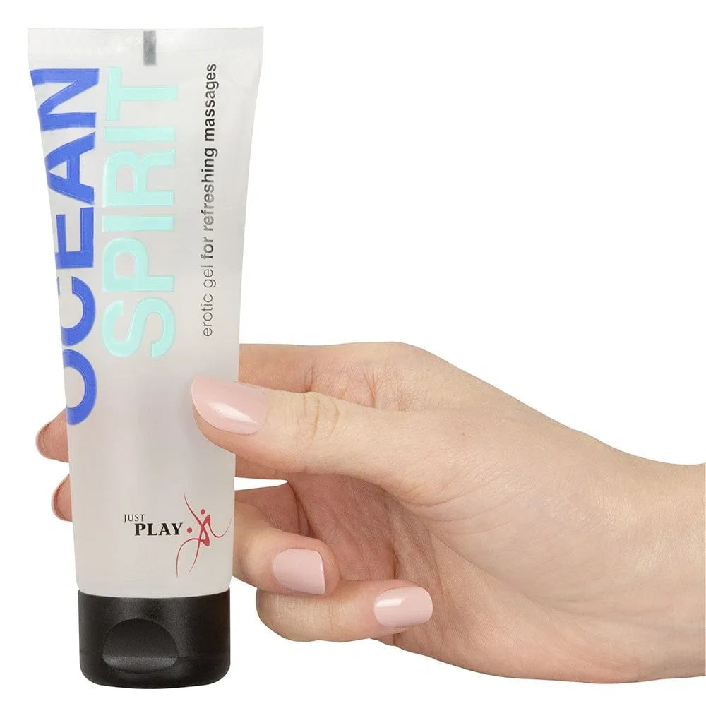 Tube de gel massage érotique végétalien, design épuré, effet rafraîchissant, glisse longue durée, main tenant le produit.