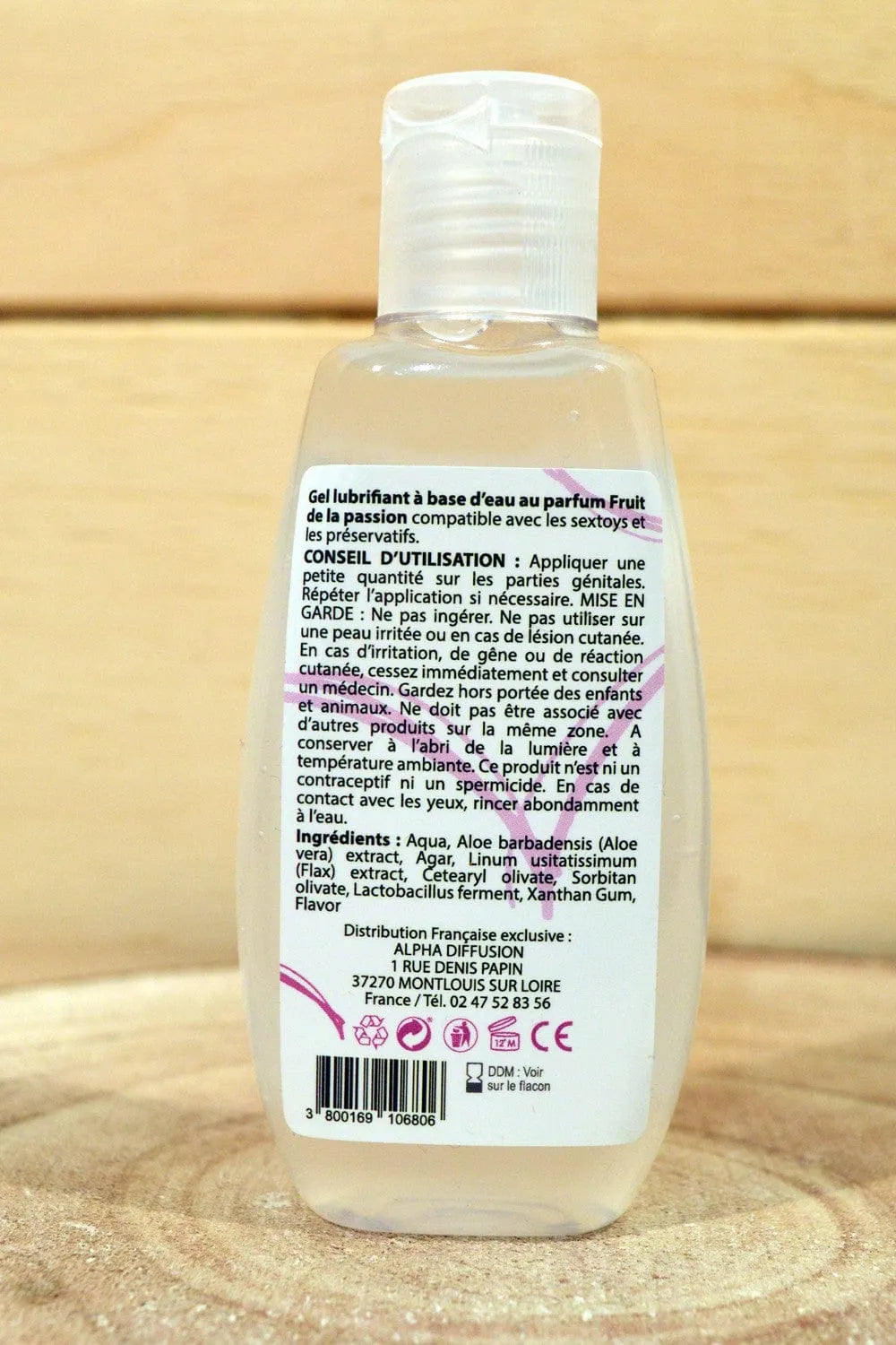 Flacon transparent de gel lubrifiant naturel fruité passion, compact, avec étiquette informative, idéal pour moments intimes.