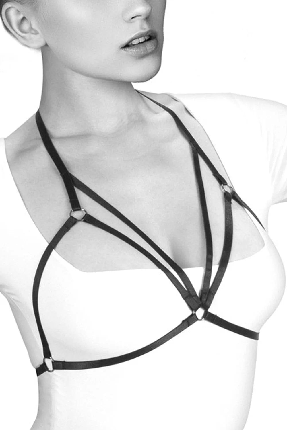 Harnais noir en polyester extensible, design audacieux avec élastiques réglables, porté sur une tenue blanche.