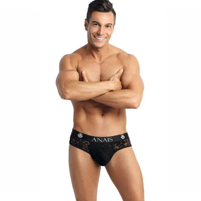 Homme portant un bikini jock noir Anais en dentelle florale, coupe audacieuse révélant les fesses, fond blanc.
