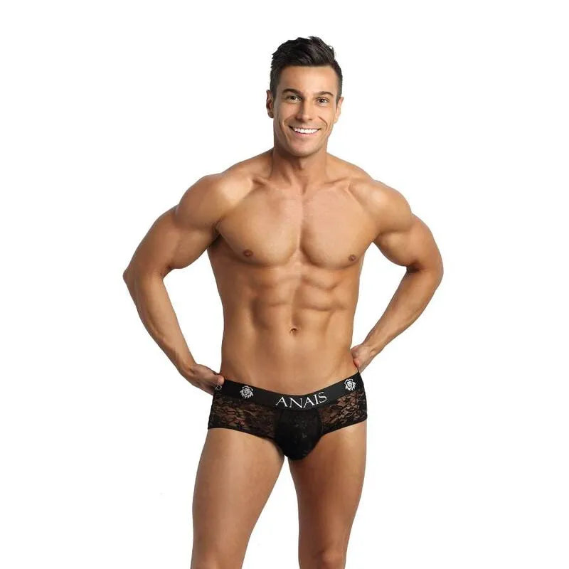 Homme portant un bikini jock noir en dentelle florale, coupe audacieuse, révélant les fesses, par Anais Apparel.