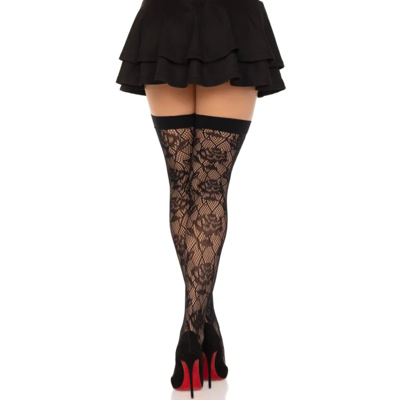 Bas résille noirs avec motifs roses sauvages brodés, élégants et romantiques, portés avec jupe noire et talons hauts.