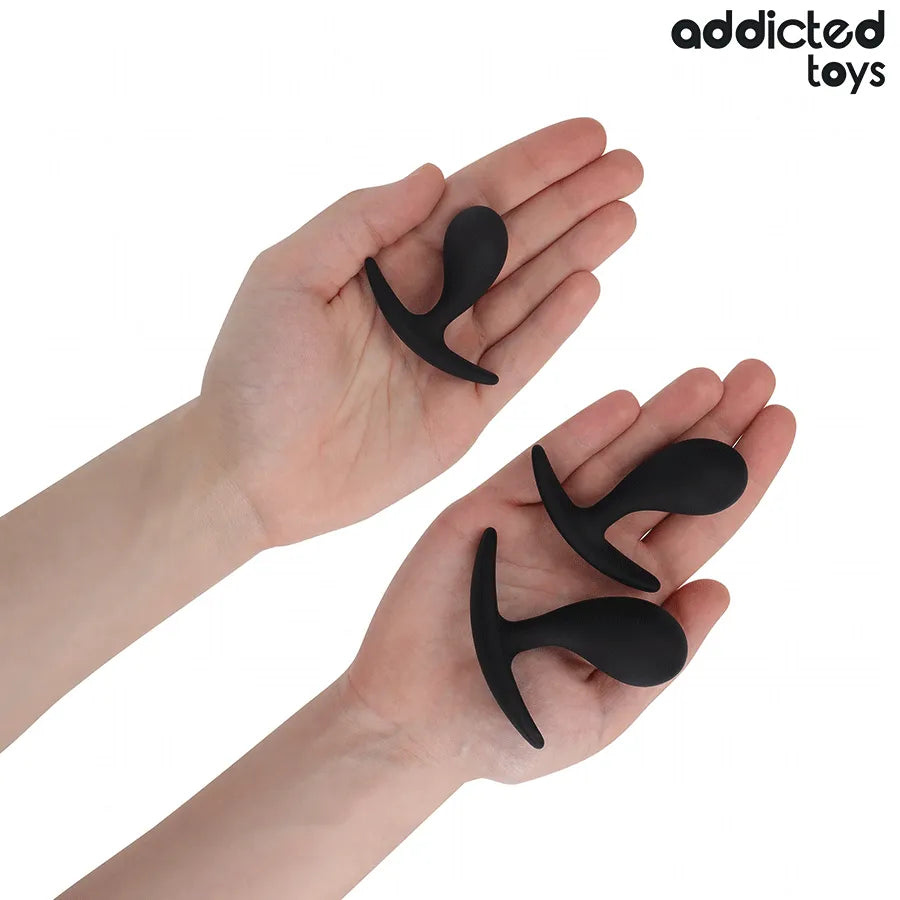 Ensemble de trois bouchons anaux noirs en silicone médical, formes progressives, base élargie, sur fond blanc.