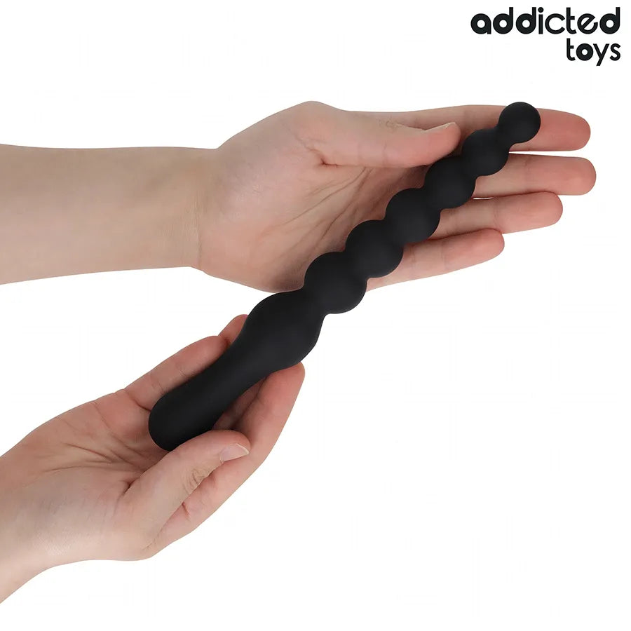 Massager anal noir en silicone médical, 24 cm, avec sphères graduées et base large, tenu par des mains.
