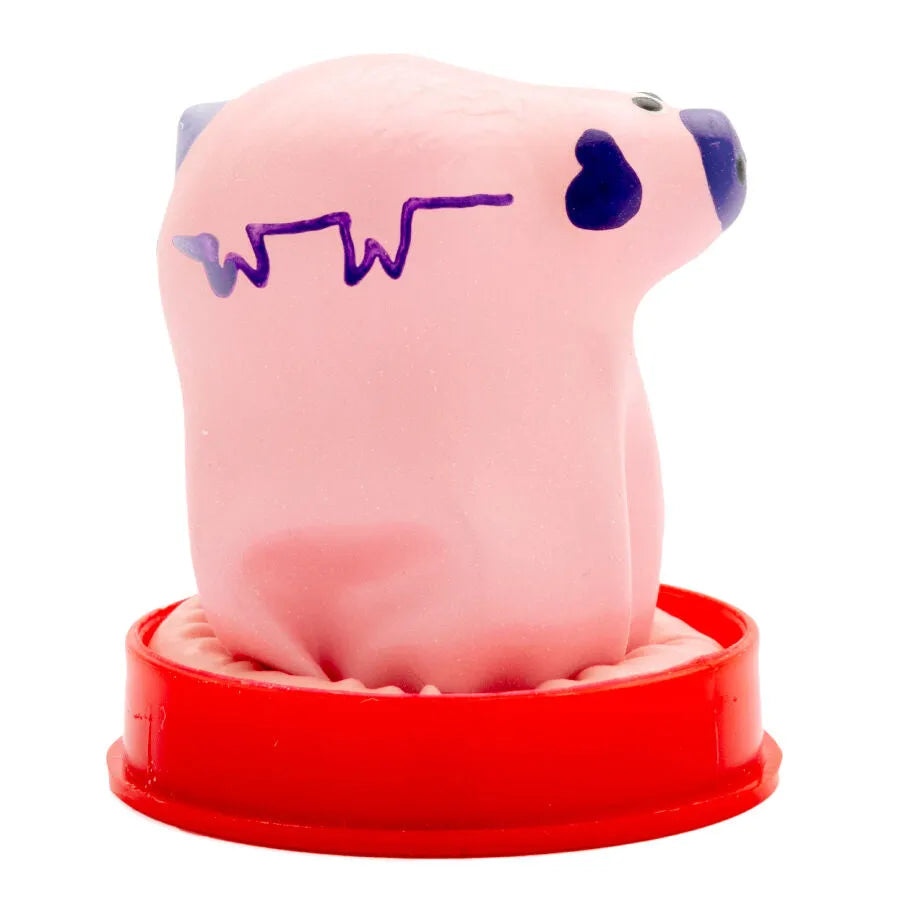 Préservatif fantaisie rose peint à la main en forme de petit cochon, détails violets, sur socle rouge.