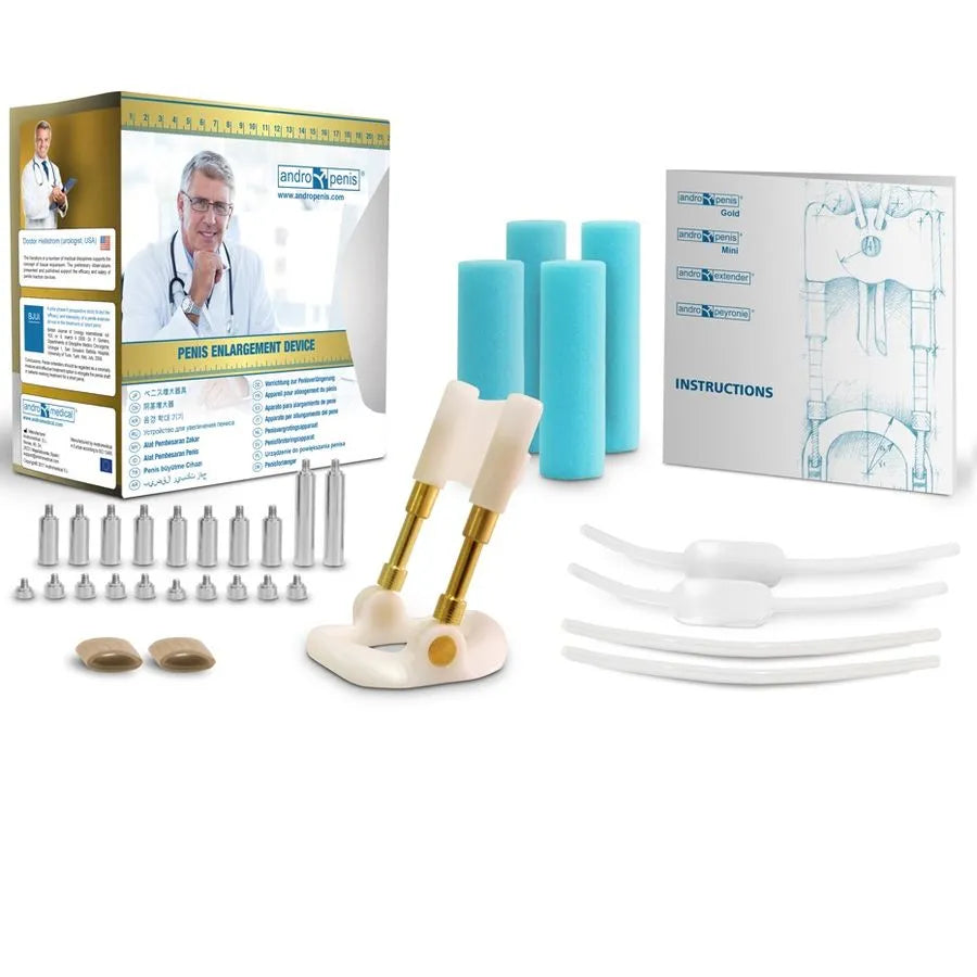 Extenseur pénien Andropenis Gold, doré 24 carats, avec accessoires et manuel, sur fond blanc.