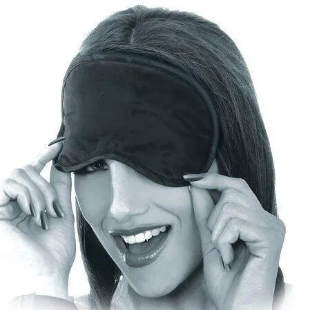 Masque satin noir élégant sur visage souriant, accessoire du kit BDSM débutant avec queue de chat et menottes métal.