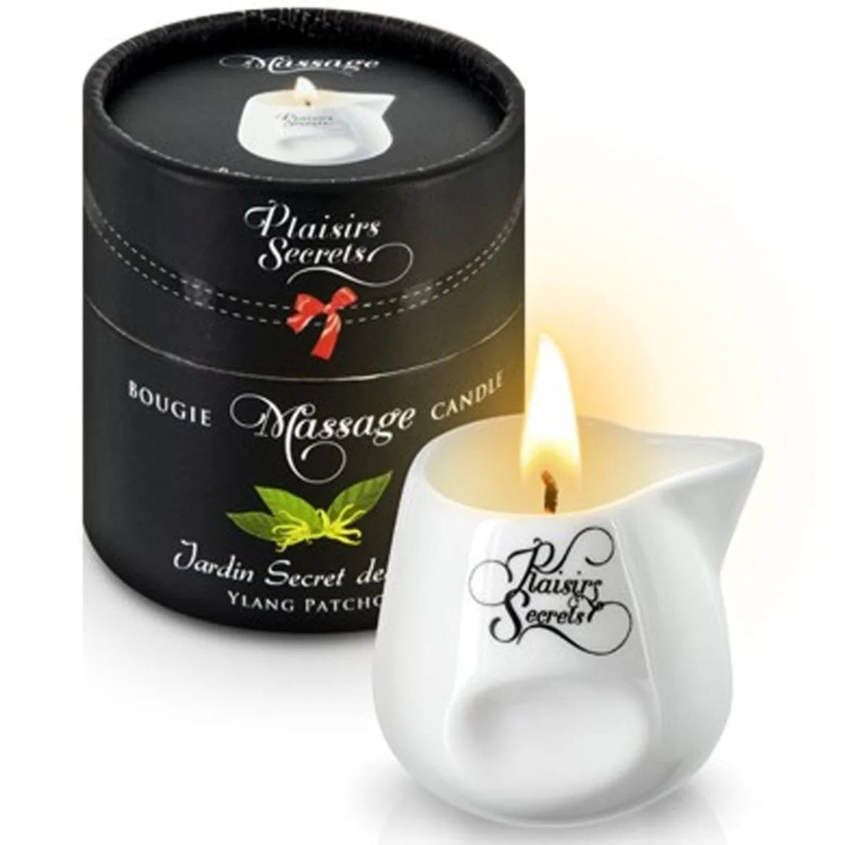 Bougie de massage ylang patchouli en céramique blanche avec bec verseur, flamme allumée, boîte noire élégante.