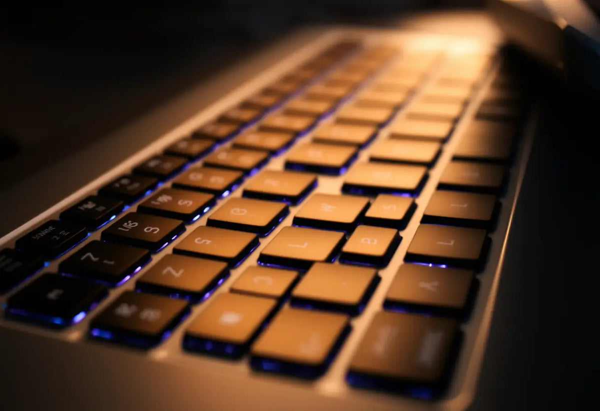 Un clavier d'ordinateur éclairé par une lumière douce, avec des touches récemment utilisées