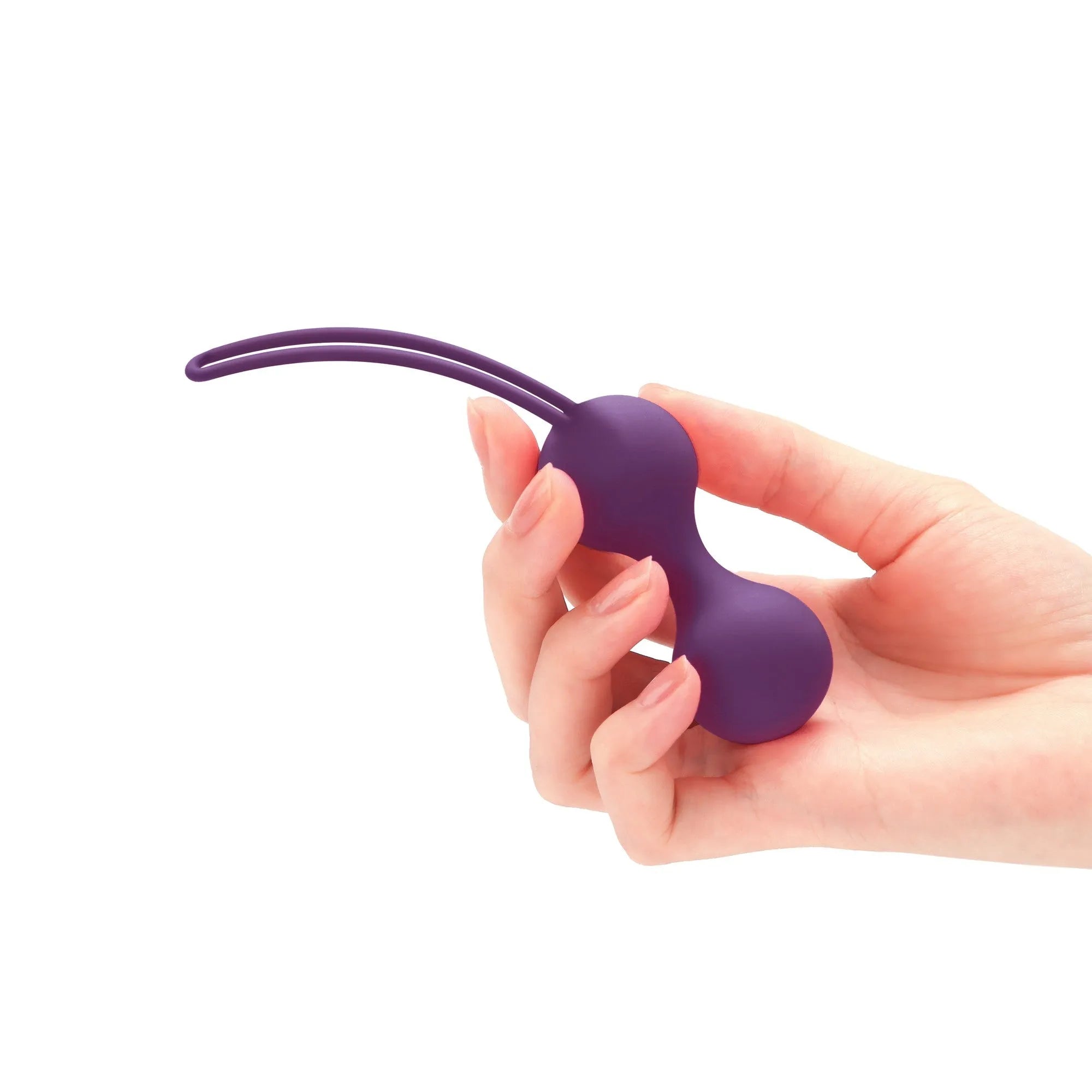 Boules Geisha violettes en silicone ergonomiques pour entraînement périnée, tenues dans une main, design discret et étanche.