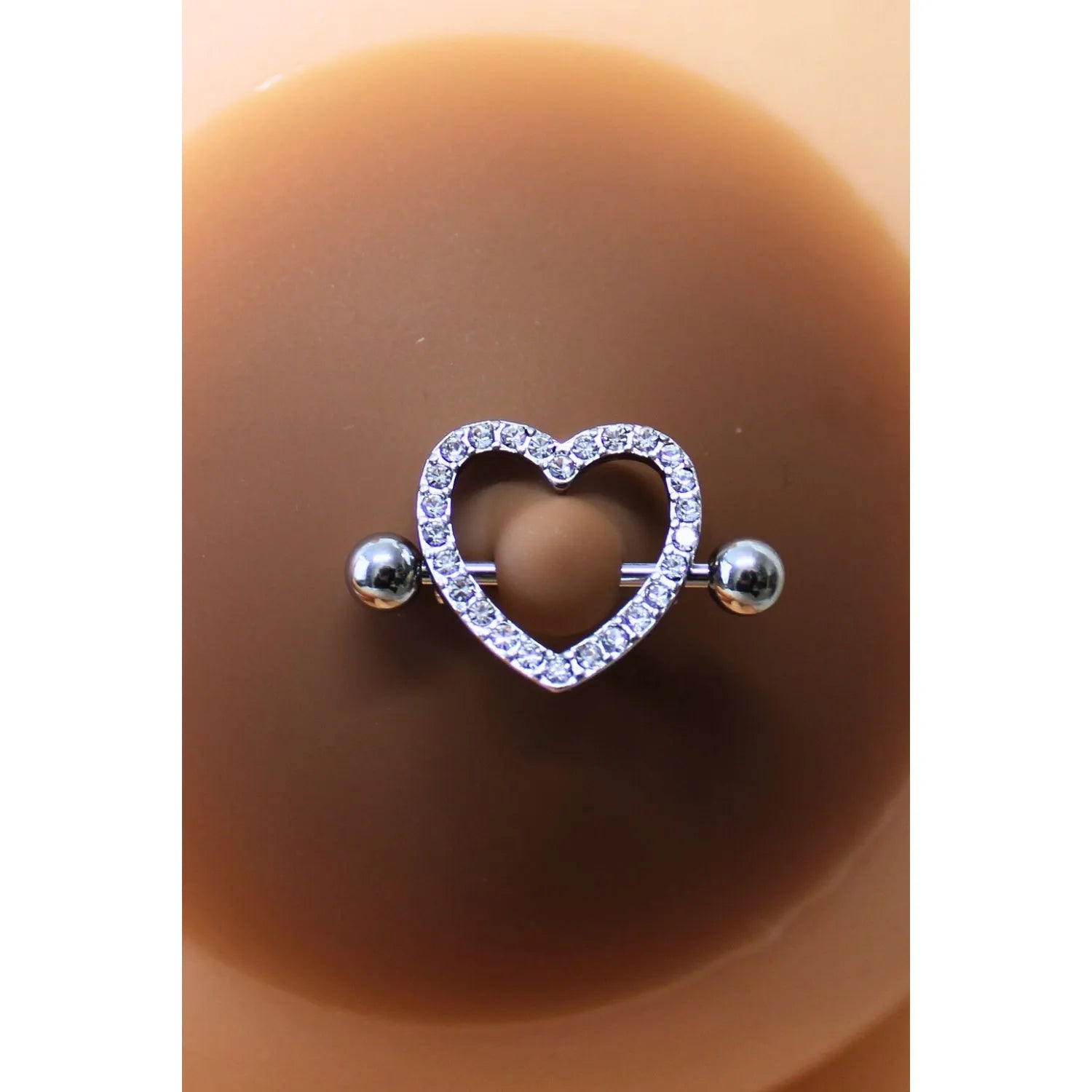 Cache-tétons silicone noir, piercing cœur faux diamant, élégant et discret, pour peaux foncées, séduction et confort.