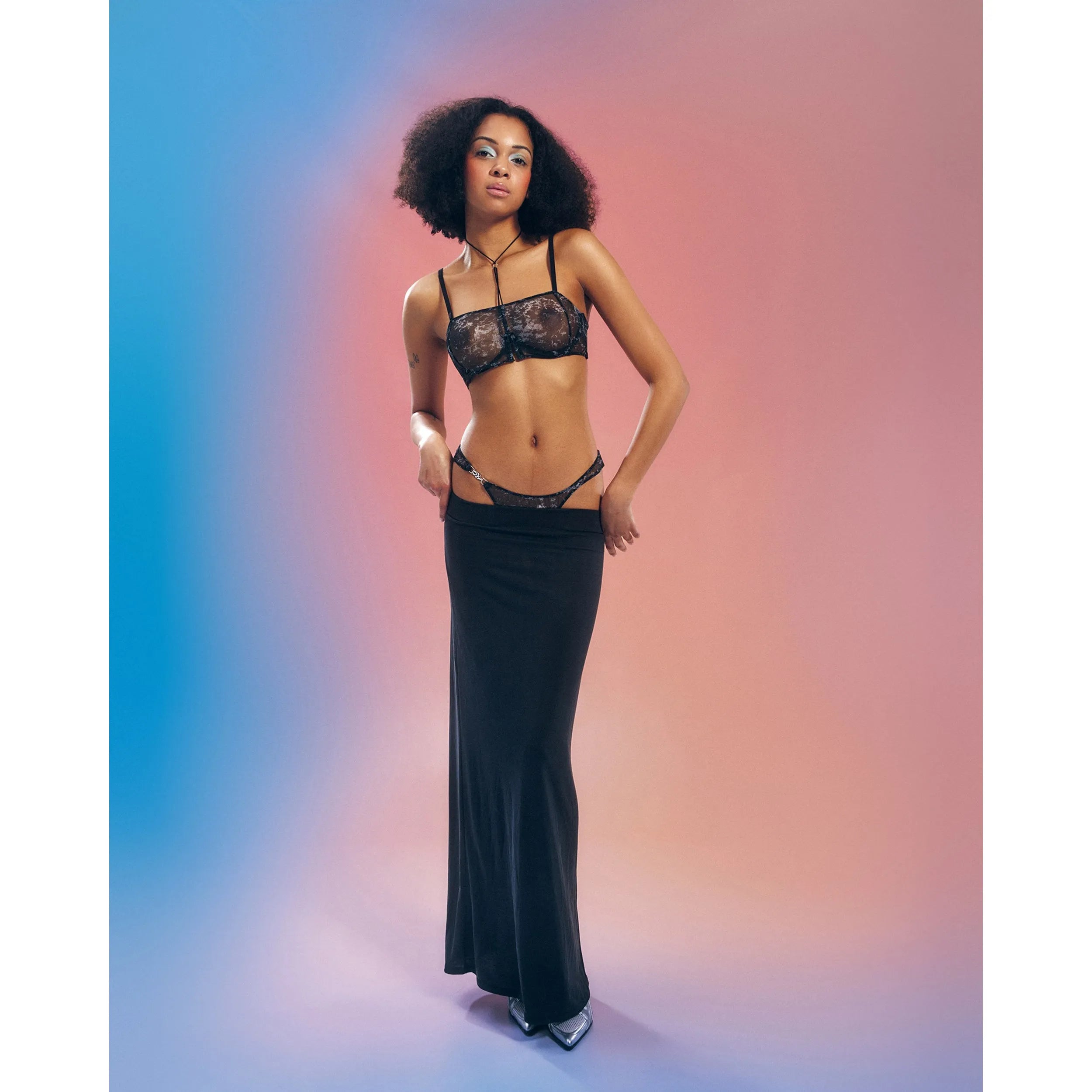 String ouvert argenté en maille transparente avec armatures, motif unique, porté par mannequin sur fond dégradé.