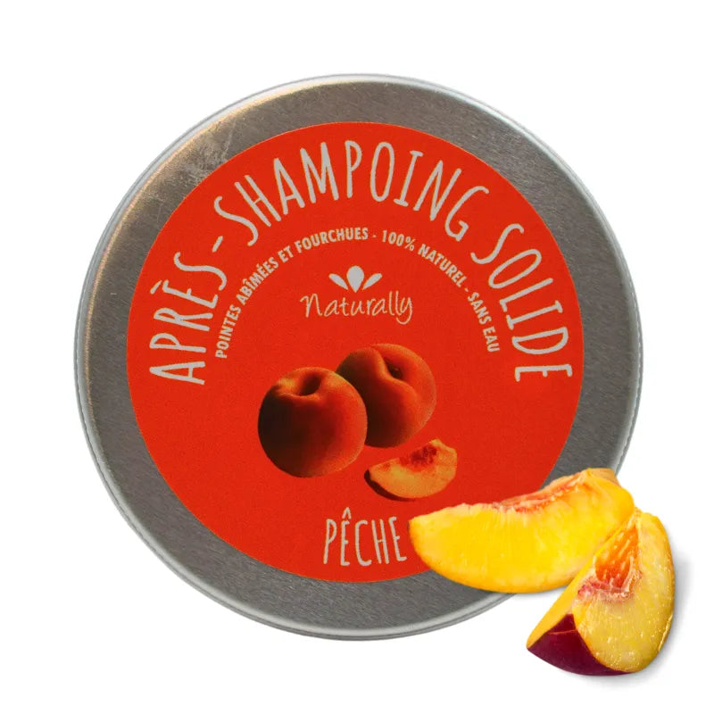 Après-shampoing solide naturel mangue pêche, boîte ronde argentée, étiquette orange avec illustrations de fruits.
