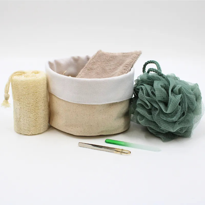 Coffret beauté zéro déchet avec accessoires réutilisables: éponge verte, lingettes beige, brosse loofah, pinceau verre.