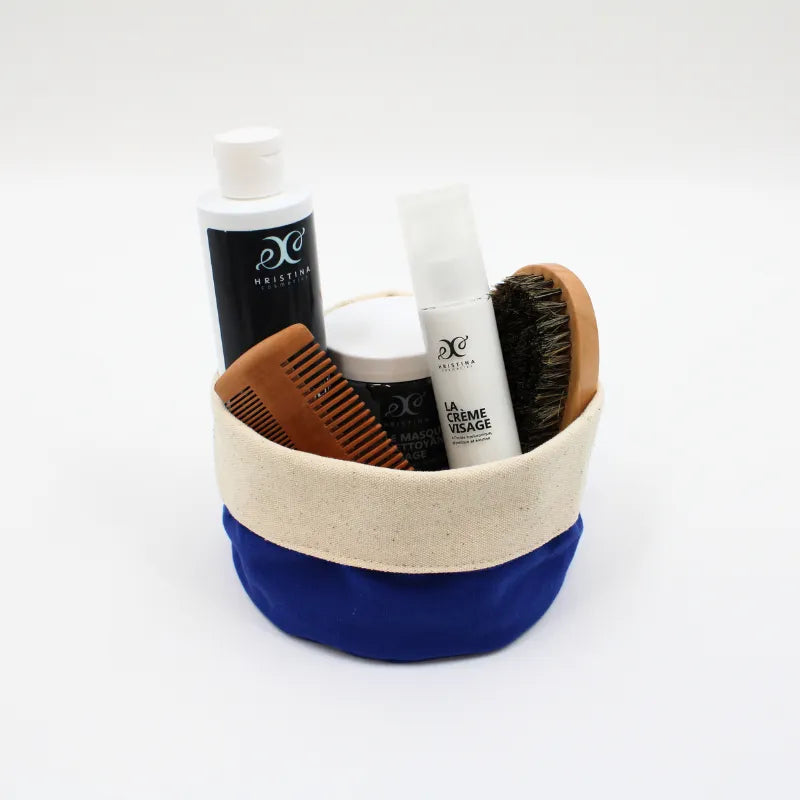 Coffret soins visage et barbe homme, produits naturels, flacons blancs, peigne en bois, brosse, pochette bleue et beige.
